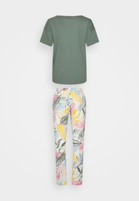Camiseta verde de manga corta con cuello redondo; pantalones blancos con un estampado colorido de hojas tropicales en tonos rosa, amarillo y azul.