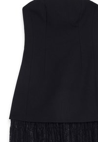 Juodas prigludęs kūnas su vertikaliomis siūlėmis, derinamas su juodo nėrinio audiniu apatineje briaunoje.