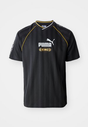 Fekete sportmez függőleges csíkokkal, kerek nyakkal és sárga díszítéssel. Az elején a "PUMA" és "KING" logók találhatók.