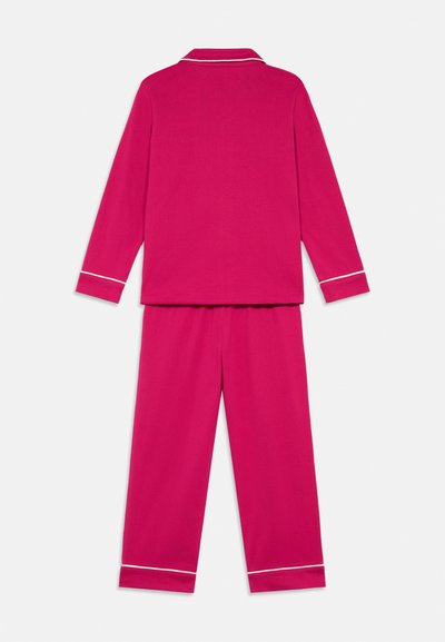 Set de pijama fucsia dintr-un material moale, cu mâneci lungi și pantaloni, având dungi albe de-a lungul gulerului și manșetelor.