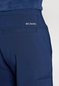 Morske plave vanjske hlače od mekanog materijala, s stražnjim džepom i Columbia logom, glatke teksture i kroja koji se savršeno prilagođava.