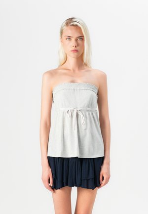 Lichtgrijs strapless top met een elastische smock-bodice en een taille met trekkoord, gecombineerd met een gelaagde marineblauwe rok.