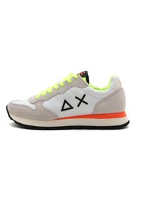 Sneaker sportivo con tomaia in pelle bianca, dettagli in suede grigio, lacci verde neon, logo nero e intersuola arancione su suola in gomma nera.