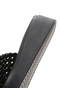 Talons compensés noirs pour sandales avec semelle texturée et dessus décoratif orné de perles rondes brillantes.