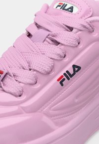 Pinke Sportschuhe mit strukturierten Schnürsenkeln, Fila-Logo in Rot und Marineblau, glattes synthetisches Obermaterial und ein elegantes, geschwungenes Sohlen-Design.