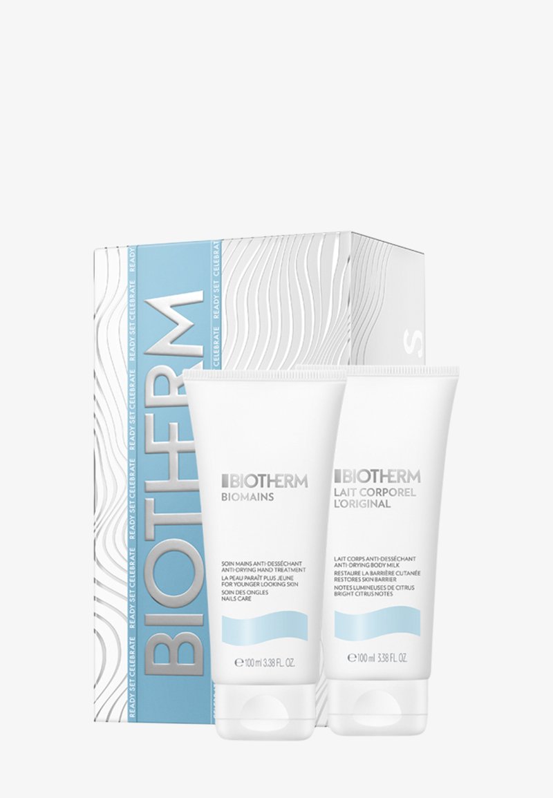 Zestaw kosmetyków Biotherm z dwoma białymi tubkami (po 100 ml każda) oznaczonymi jako "Biomains" i "Lait Corporel", w teksturowanym niebiesko-białym pudełku.