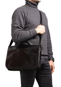 Borsa a tracolla in pelle nera con finitura lucida, forma rettangolare, tracolla regolabile e dettagli di cucitura sottili.