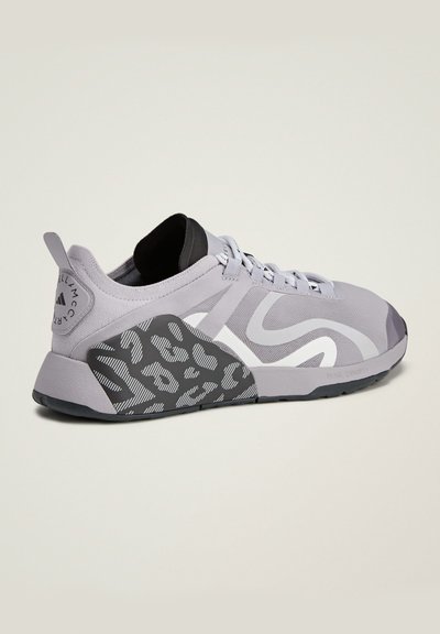 Gray athletic shoe featuring a dual-density design, textured side panel, and flat laces. Includes subtle white accents and a black lining.