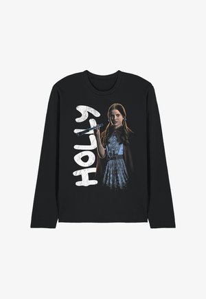 Girl with long hair in a blue dress and cape holding a wand, with the word "HOLLY" in large white letters beside her on a black long-sleeve shirt.