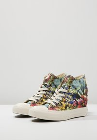 Hoge sneakers met een multikleurig bloemmotief, gemaakt van canvas, met een witte rubberen zool en beige veters. Verfraaid met metalen oogjes.