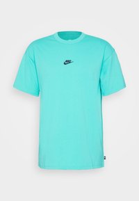 Turkos bomullströja med korta ärmar och rund halsringning. Har en liten svart Nike-logotyp på bröstet. Enkel, odekorerad design.