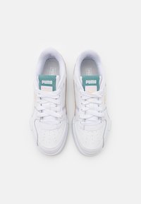 Vita sneakers med en slät läderövre, som har perforeringar, snörning och en mintgrön och rosa logotags på tungan.