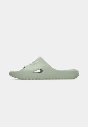 Világos zöld, zárt orrú, nyitott oldalsó részes slip-on szandál, texturált talppal, fehér háttér előtt, oldalnézetből bemutatva.