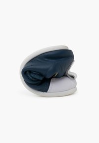 Chaussure en cuir bleu avec un design plié, dotée d'une semelle texturée blanche et d'un intérieur en tissu doux. Les accents incluent une couture sur le bord.