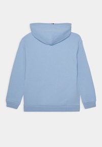 Světle modrá mikina s kapucí, měkkého materiálu, s žebrovanými manžetami a lemem, s centrálním švem na zadní straně a minimalistickými detaily.