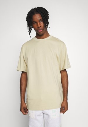 Beige oversized t-shirt van katoen, met korte mouwen en een ronde hals. Gladde textuur en een relaxte pasvorm.