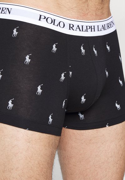 Juodi medvilniniai boxeriai su balta polo žaidėjo raštu, turintys baltą juosmens juostą su užrašu "POLO RALPH LAUREN". Minkšta tekstūra, priglustantis dizainas.