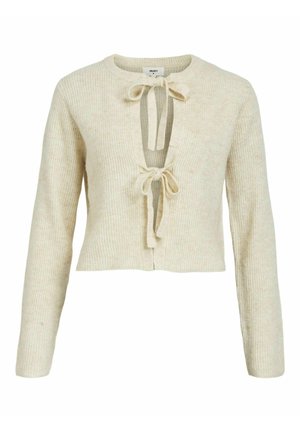 Pull en maille côtelée beige à manches longues, design court et décolleté en V profond avec deux liens à l'avant. Texture douce et matériau en tricot.