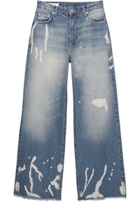 Jean en denim bleu à jambes larges avec taille haute et taches de javel blanches éparpillées sur le devant et les jambes.
