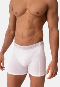 Boxers de algodón blancos con una cinturilla gris que presenta el texto "DANISH ENDURANCE". La tela parece suave y ajustada.