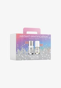 Ensemble de soins de la peau Sunday Riley étiqueté Satisfaction Instantanée, avec les bouteilles Good Genes et Auto Correct dans un emballage violet et argenté.