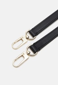 Sangle en cuir noir avec crochets pivotants en métal doré à chaque extrémité sur un fond blanc.