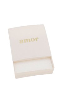 Scatola rettangolare bianca con un coperchio curvo, caratterizzata dalla parola "amor" in lettere dorate. L'interno è foderato con morbido feltro bianco.