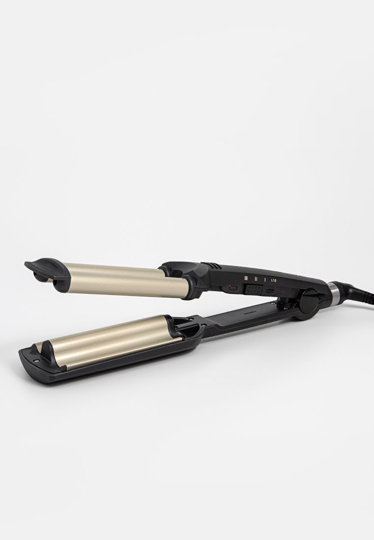 Plancha de pelo con cuerpo de plástico negro y cilindros de metal dorado. Presenta botones de control, luces indicadoras y un cable de alimentación resistente.