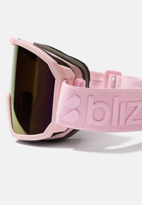 Roze skijaške naočale imaju veliki tamni gradijentni leća, okvire od crne pjenaste jastučića i teksturirani roze remen s utisnutim logotipom.