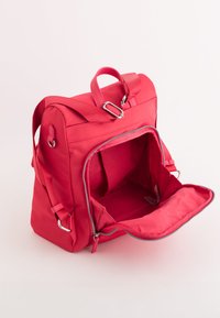 Rucsac sintetic roșu cu o formă rectangulară, dotat cu două mânere, bretele ajustabile și un compartiment principal cu fermoar, având un interior moale.