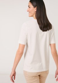 White short-sleeve t-shirt made of soft cotton, featuring a simple round neckline and a relaxed fit, displayed from the back.
