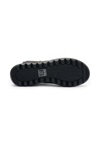 Suela de zapato con una superficie de goma negra texturizada, que presenta un patrón de olas y bordes acanalados para mayor tracción. Incluye la etiqueta de la marca "Arca High Soft."