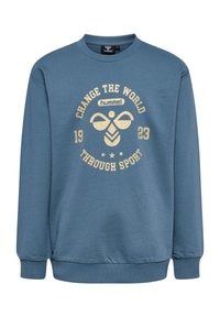 Ljusblå sweatshirt med rund halsringning, med en guldtryckt design som säger "FÖRÄNDRA VÄRLDEN GENOM SPORT 1923" och subtila detaljer.