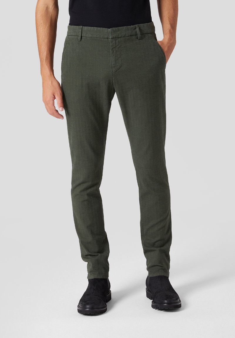 Pantaloni in cotone verde con una vestibilità slim e una texture sottile. Presentano una vita standard, tasche frontali e un design piatto.