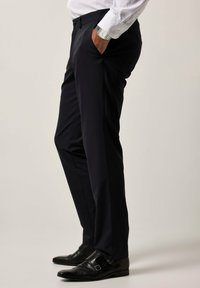 Marineblauwe dress pants met een soepele textuur, een slim fit en een vlakke voorkant. Gecombineerd met zwarte schoenen met een gespsluiting.
