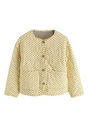 Żółta pikowana kurtka z czarnymi groszkami, okrągłym dekoltem, guzikami z przodu, dwoma przednimi kieszeniami oraz paskowanym podszewką.