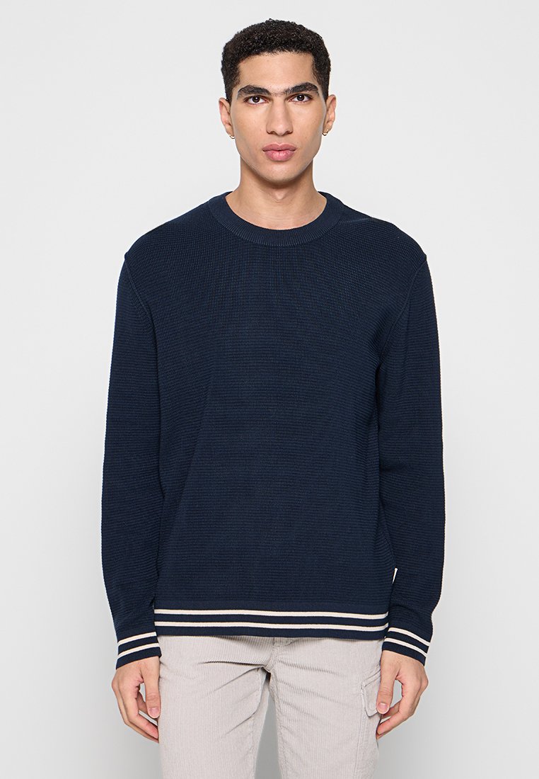 Dunkelblauer Strickpullover mit gerippter Textur, Rundhalsausschnitt und kontrastierenden weißen Streifen an den Bündchen und am Saum. Lange Ärmel, normale Passform.