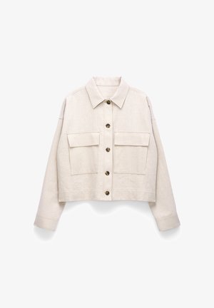 Veste courte beige à manches longues, fermeture à boutons sur le devant, deux poches poitrine à rabat et col pointu.