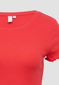 Rode geribbelde t-shirt met korte mouwen en ronde halslijn, met een klein maatlabel dat binnenin de kraag is genaaid, op een effen lichte achtergrond.