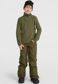 Fleece-pullover och byxor i mörk olivgrön. Pullovret har en halvdragkedja i kragen; byxorna är vida med en logotyp-patch på sidan.