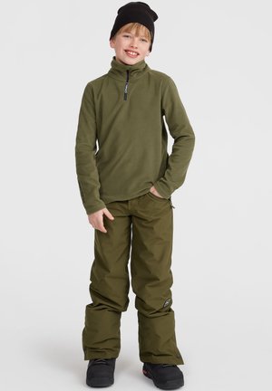 Pull en polaire et pantalons en vert olive foncé. Le pull est doté d'un col zippé à moitié ; les pantalons sont amples avec un patch logo sur le côté.