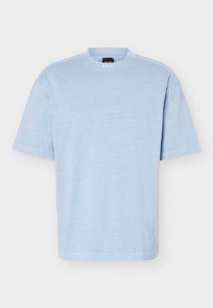 T-shirt à manches courtes bleu clair avec col rond, tissu doux et coupe décontractée, présentant une petite étiquette de marque noire et orange à l'intérieur du col.