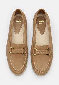 Braune Lederloafers mit goldfarbenen Hardwareakzenten, abgerundeter Spitze und kontrastierenden Nähten. Weicher Stoff mit glatter Innenauskleidung.