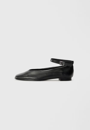 Bailarinas de couro pretas com bico fino e uma tira fina no tornozelo, apresentando um salto baixo e textura suave. Design simples e minimalista.