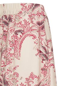 Tissu beige avec des motifs paisley et floraux complexes en rouge, gris et rose, comprenant des détails de taille élastique froncée.