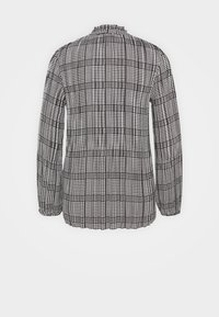 Czarna i biała w kratkę bluzka z długim rękawem, z marszczeniem przy dekolcie i elastycznymi mankietami, wykonana z tkaniny o teksturowanym wzorze.