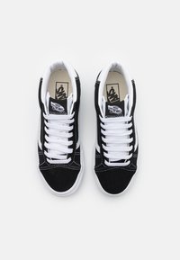 Zwarte suède sneakers met witte veters en rubberen zolen. Voorzien van een gevoerde kraag, witte zijstreep en logo op de tong.