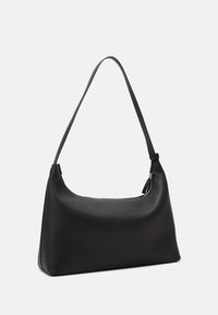 Svart läderaxelväska med en böjd form, enkel rem och dragkedjeförslutning. Mjuk textur med minimal detaljering och utan synliga metalldelar.