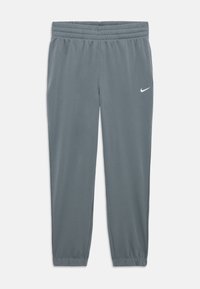 Pantalons de survêtement gris Nike avec une taille élastique et des poignets élastiques, présentant un petit logo Nike en blanc sur la cuisse gauche.