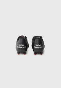 Black soccer cleats with red accents. Features a smooth synthetic upper, prominent branding, and multiple studs on a durable outsole.